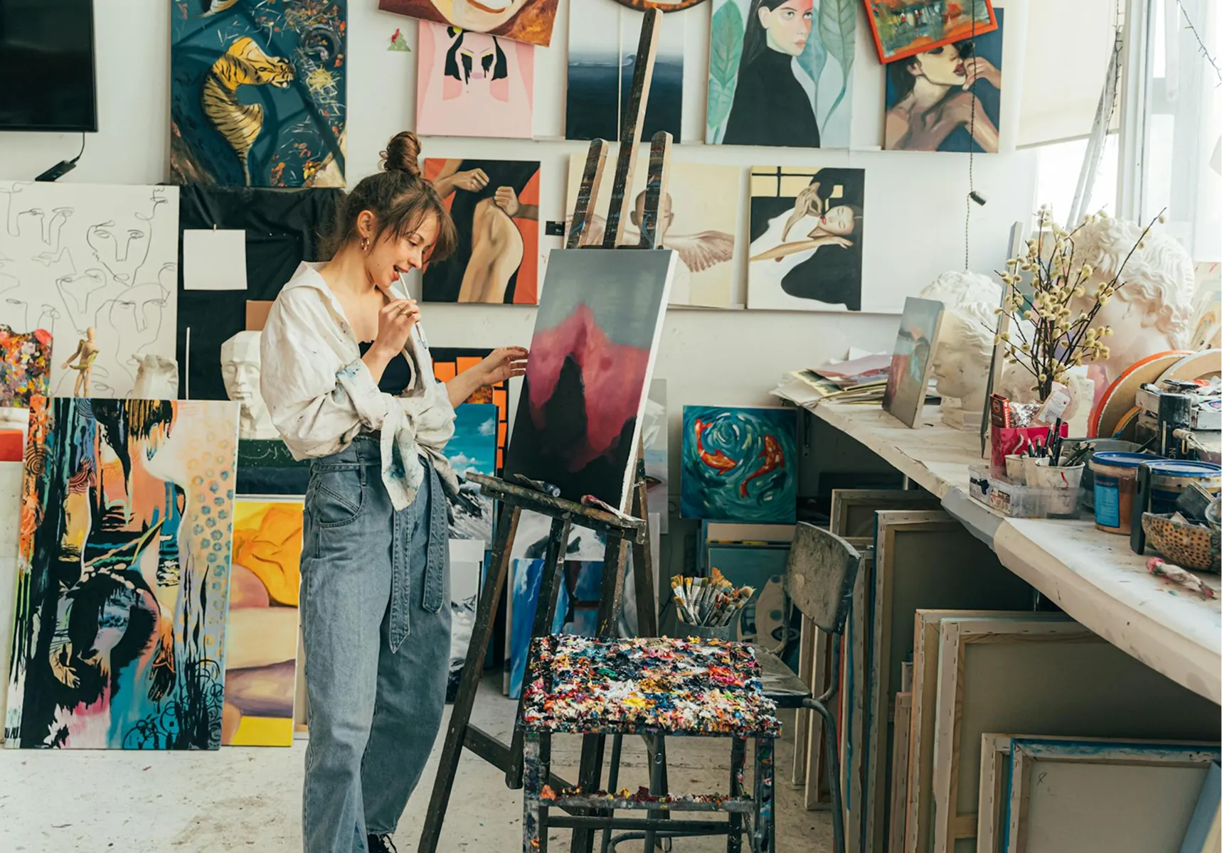A person painting in a bright art studio
